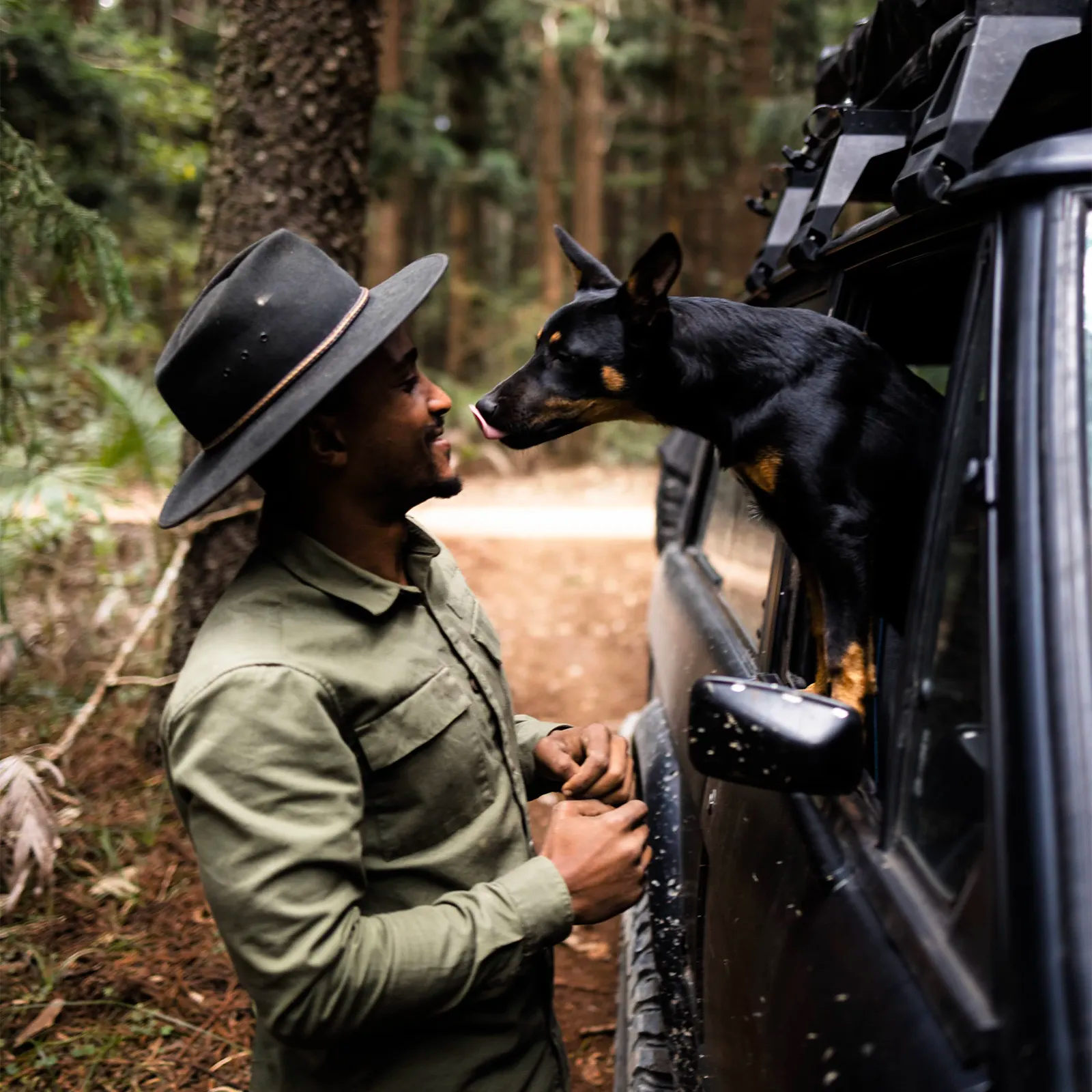 Endak and Zila, a black kelpie playing around at the side of a Range Rover Classic | Range Rover Adventures | Range Rover Classic | Range Rover Restoration | Range Rove Build | Overlanding Range Rover Classic | Touring Range Rover Classsic