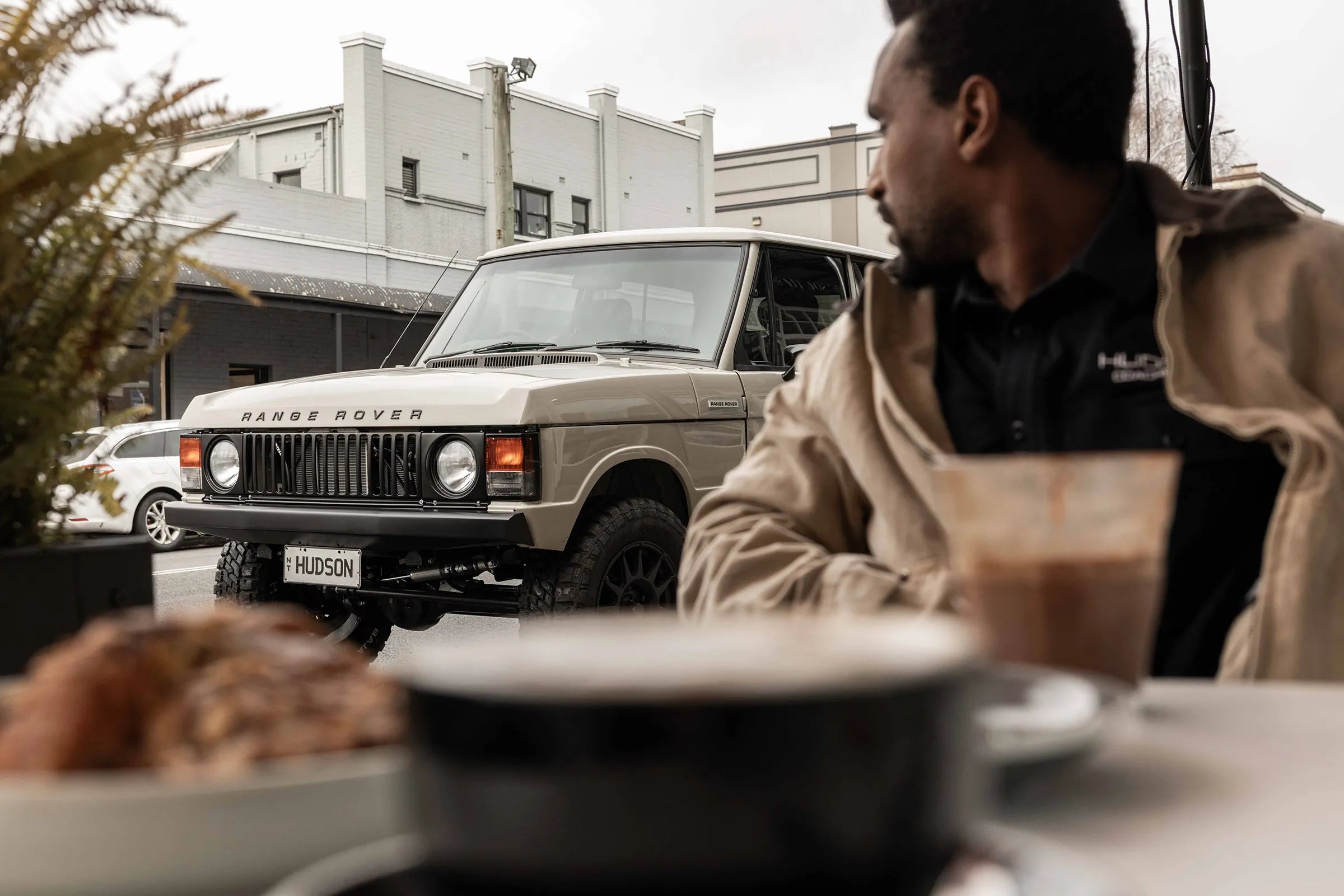 Hudson Coachworks Signature series Range Rover Classic parked outside coffee shop with man looking at it | Range Rover Classic | Range Rover Coachworks | Range Rover Restorations | Range Rover Build | LS Range Rover | V8 Range Rover | Supercharged Range Rover