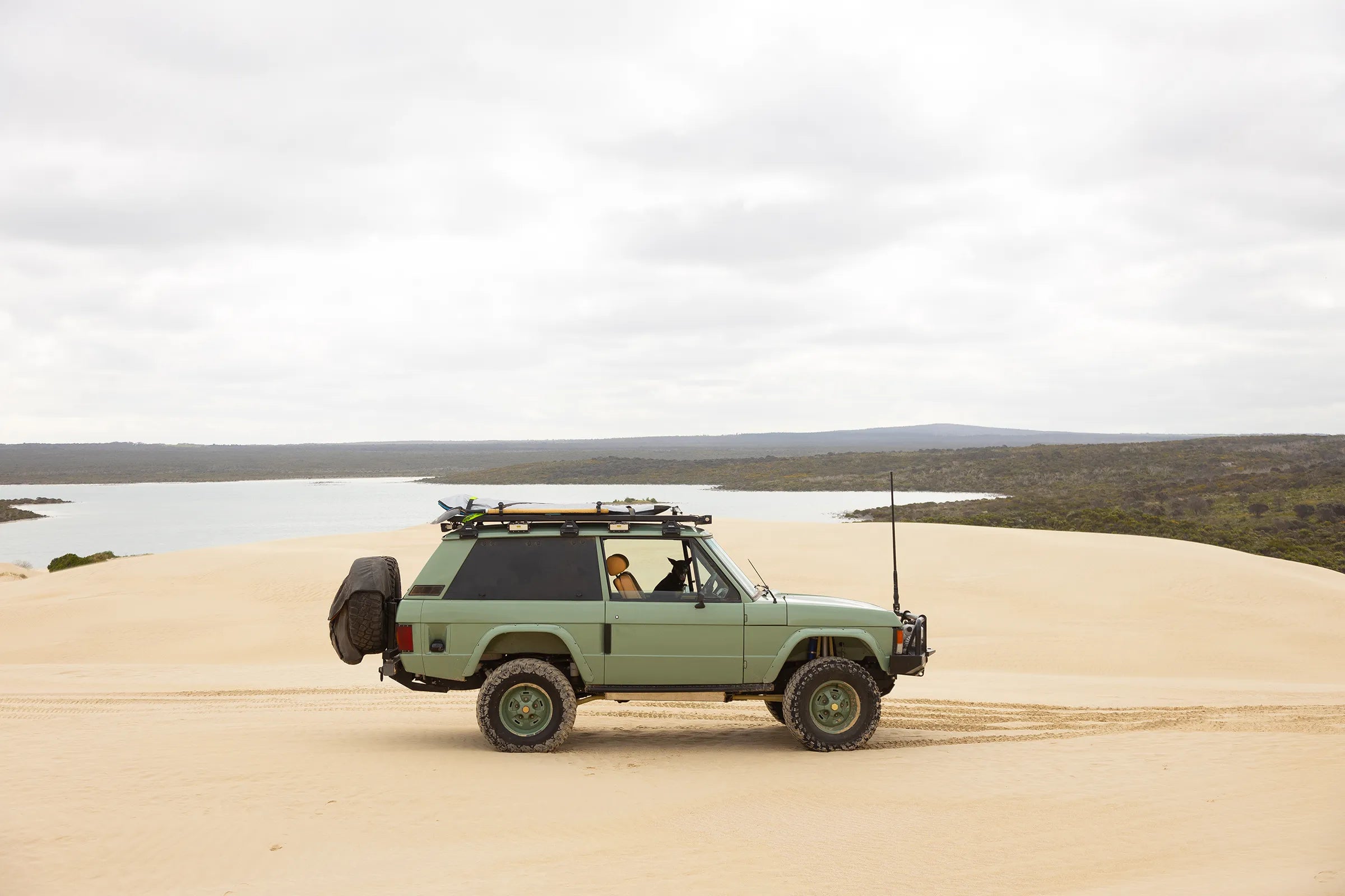 Hudson Coachworks Range Rover Classic expedition series on top of sand dunes with ocean inlet background | Range Rover Classic | Range Rover Build | Range Rover restoration